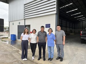 People standing outside of a new warehouse in Thailand.